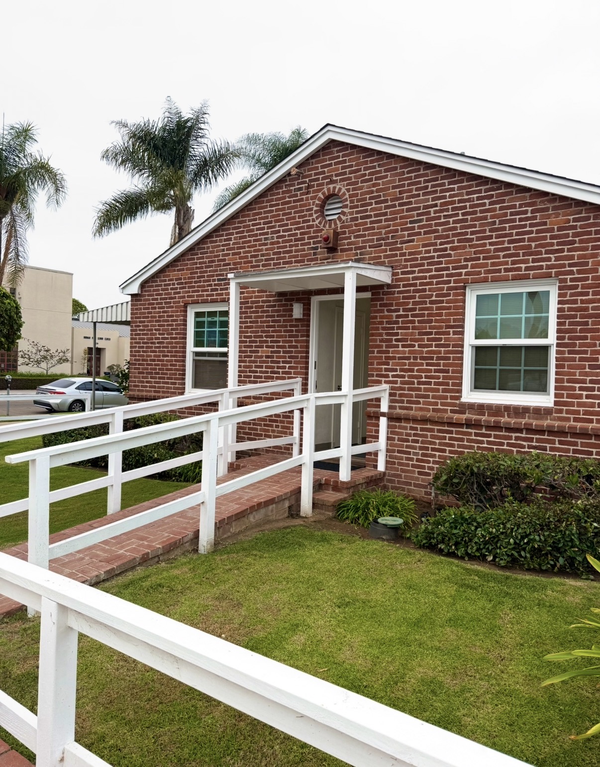 The wheelchair-accessible brick ramp with white railings leading to the San Diego Bay Dental entrance