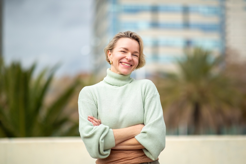 Smiling woman in a light green sweater outdoors