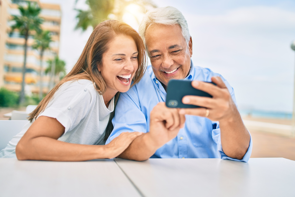 Older couple looking at a smartphone outdoors