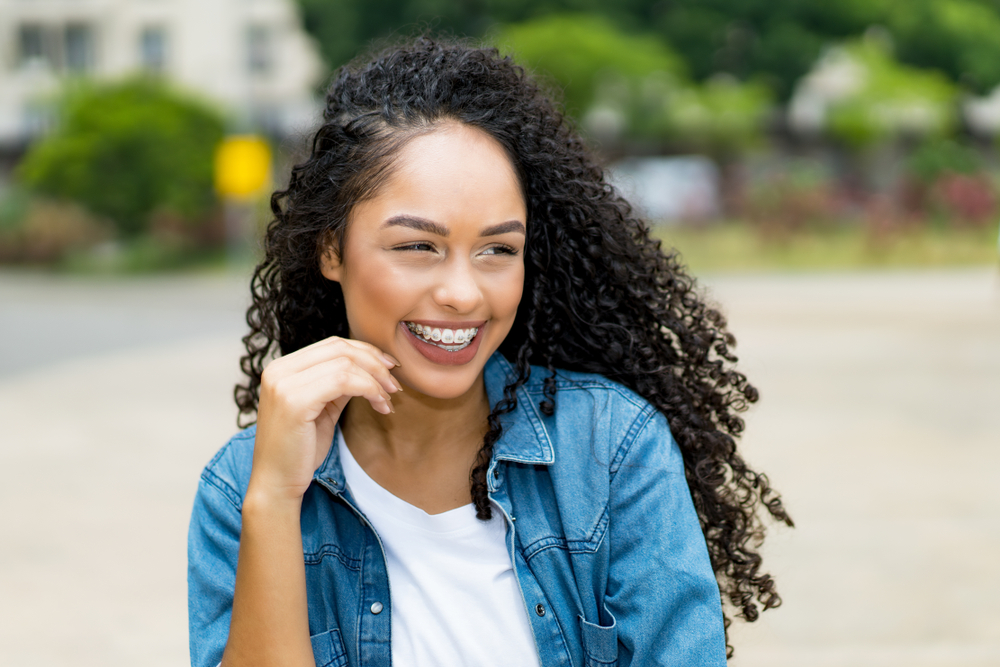 Young woman with braces smiling outdoors